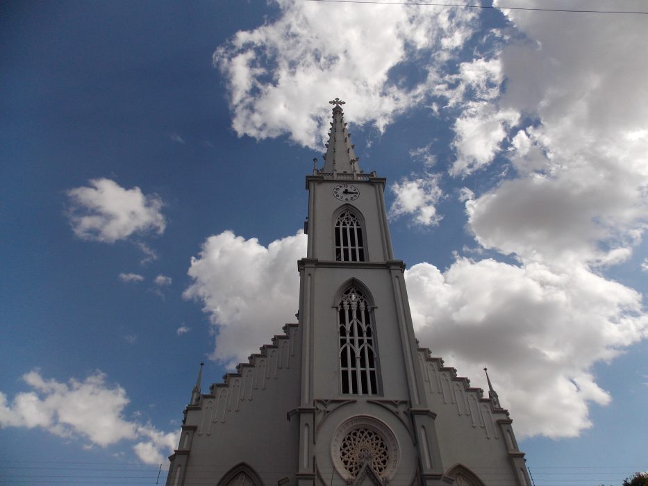 foto colorida da Igreja Matriz de São Luis Gonzaga vista de baixo para cima com céu e nuvens ao fundo