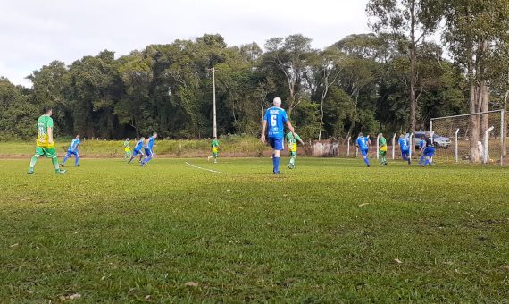 foto colorida de jogo comemorativo do Beija-Flor. Gramado com jogadores de futebol vestidos com uniforme azul