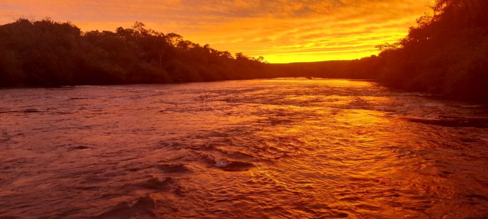 Foto colorida do rio Inhacapetum ao pôr do Sol 
